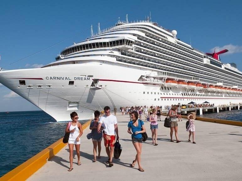 Crucero atracado en el muelle con pasajeros bajando a tierra