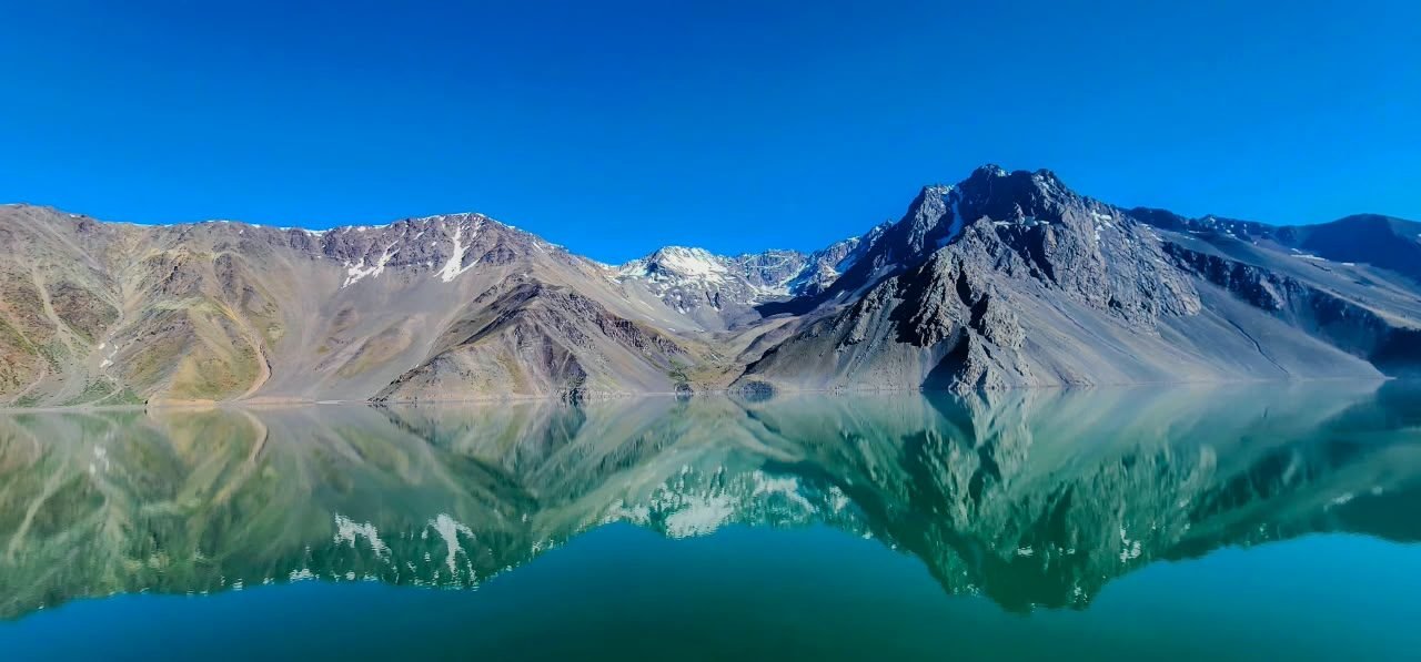 Embalse turquesa reflejando montañas nevadas cerca de Santiago de Chile